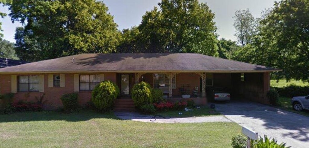 single story home featuring a front yard and a carport