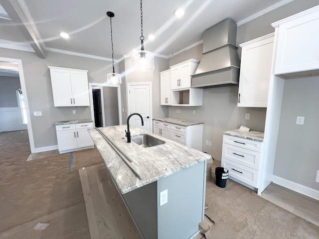5015 Charnwood Forest Cir, Aiken, SC 29803 - kitchen with a sink, premium range hood, a center island with sink, crown molding, and light stone countertops