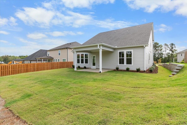 rear view of house featuring a patio and a lawn