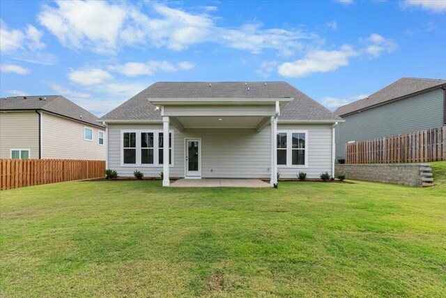 rear view of house featuring a yard and a patio area