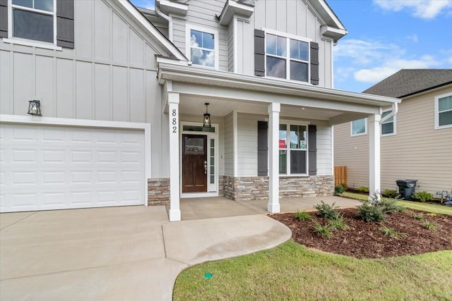 view of exterior entry featuring a porch and a garage