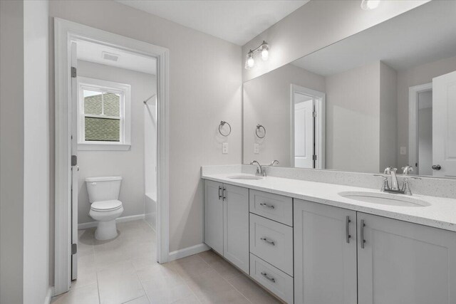 bathroom featuring tile patterned flooring, vanity, and toilet