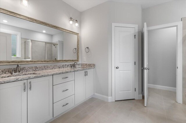 bathroom with vanity, an enclosed shower, and tile patterned floors