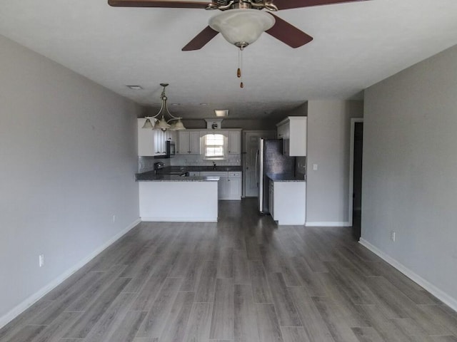 unfurnished living room featuring hardwood / wood-style flooring, ceiling fan, and sink