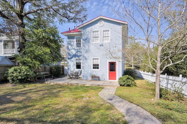 back of property with a yard, fence, and a wooden deck