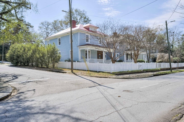 exterior space featuring a fenced front yard and a chimney