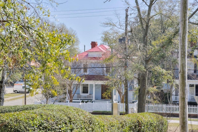 view of front facade featuring covered porch and a fenced front yard