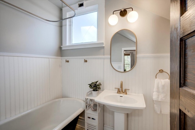 full bathroom with visible vents, wainscoting, and a freestanding tub