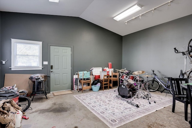 playroom featuring vaulted ceiling and unfinished concrete flooring