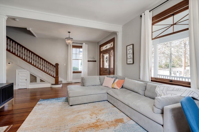 living area featuring stairs, wood finished floors, and baseboards