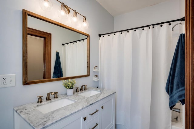 bathroom featuring curtained shower, double vanity, and a sink