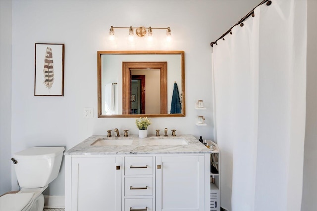 bathroom featuring a sink, toilet, and double vanity