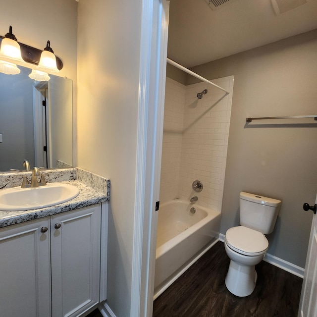full bathroom featuring vanity, wood finished floors, toilet, baseboards, and shower / washtub combination