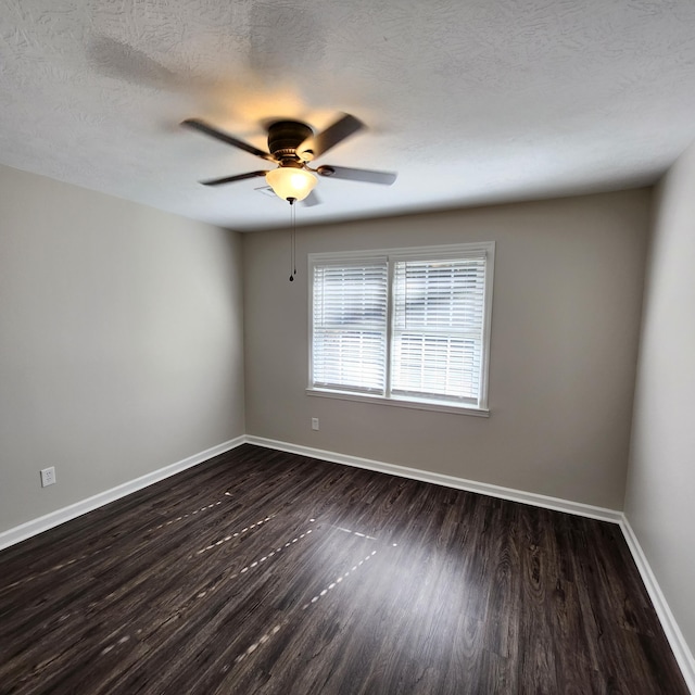 empty room with baseboards, a textured ceiling, dark wood-style flooring, and ceiling fan