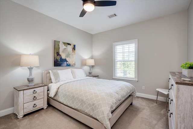 bedroom featuring light colored carpet, baseboards, visible vents, and ceiling fan