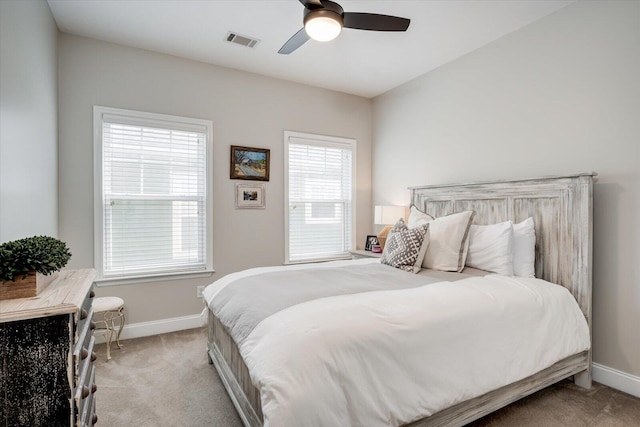 carpeted bedroom featuring baseboards, a ceiling fan, and visible vents