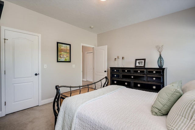 bedroom with baseboards and light colored carpet