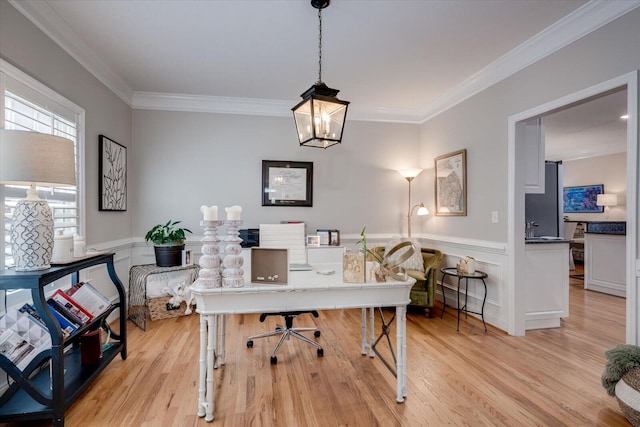 home office featuring crown molding, a wainscoted wall, and light wood-style floors