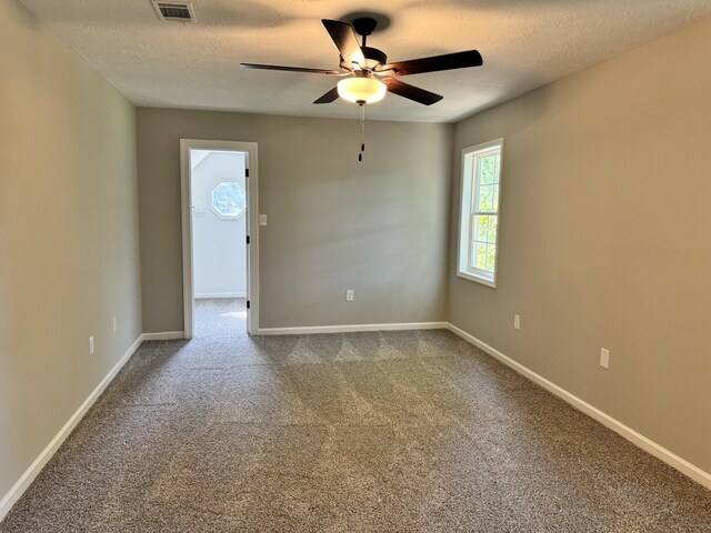 unfurnished room with ceiling fan, carpet, and a textured ceiling