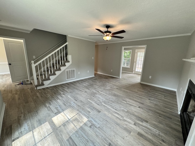 unfurnished living room with wood-type flooring, a textured ceiling, ceiling fan, and ornamental molding