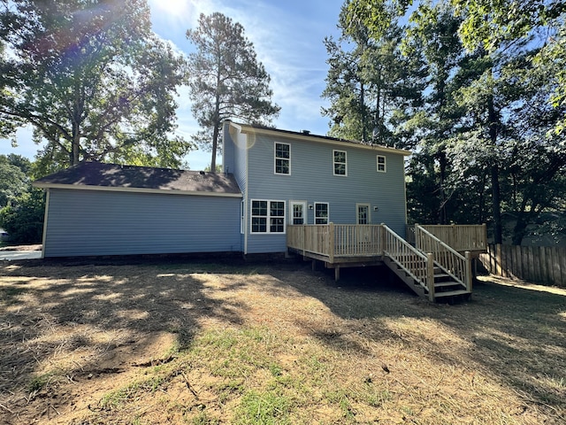 back of house featuring a lawn and a wooden deck