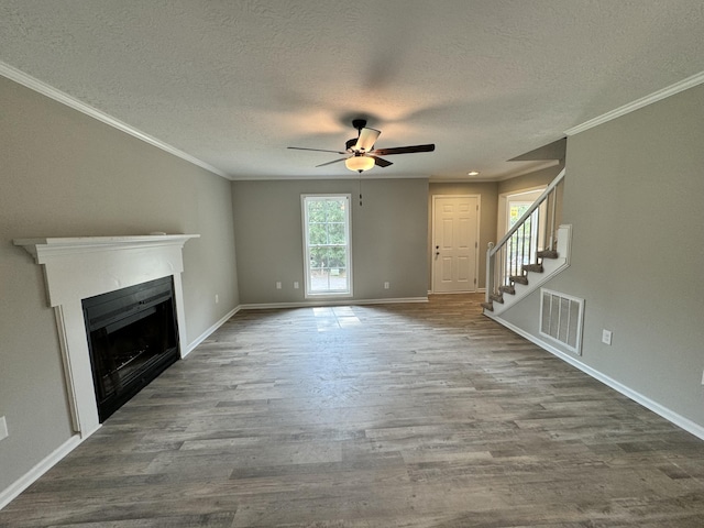 unfurnished living room with hardwood / wood-style floors, ceiling fan, ornamental molding, and a textured ceiling