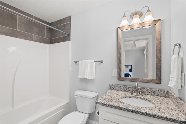 full bathroom with vanity, tiled shower / bath combo, and toilet