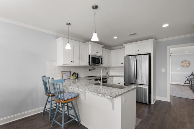 kitchen featuring kitchen peninsula, white cabinetry, stainless steel appliances, and a breakfast bar