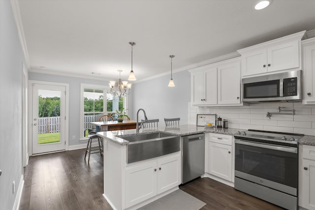 kitchen featuring kitchen peninsula, appliances with stainless steel finishes, white cabinetry, and a notable chandelier