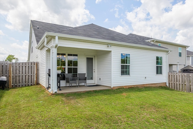 rear view of property with a lawn and a patio area