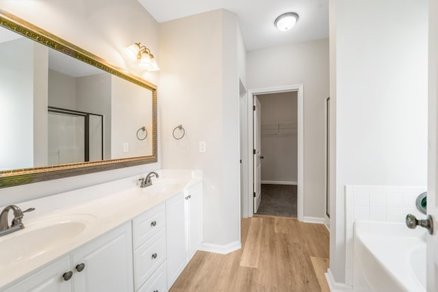 bathroom featuring separate shower and tub, hardwood / wood-style floors, and vanity