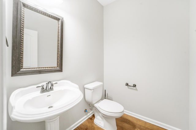 bathroom with hardwood / wood-style flooring, sink, and toilet