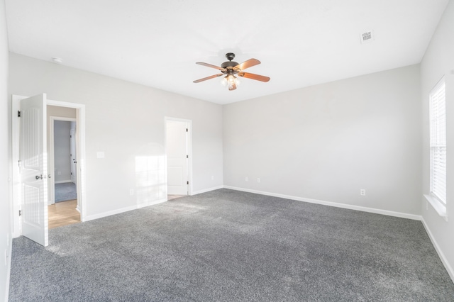 carpeted empty room with a wealth of natural light and ceiling fan