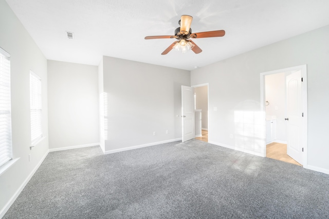 carpeted spare room featuring ceiling fan