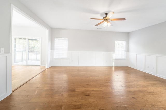 unfurnished room with ceiling fan, hardwood / wood-style floors, and plenty of natural light