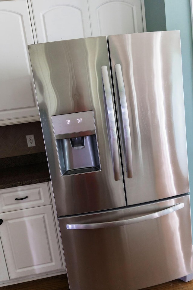1212 Sumter Landing Ln, Evans, GA 30809 - detailed view of stainless steel fridge with ice dispenser, dark countertops, and white cabinetry
