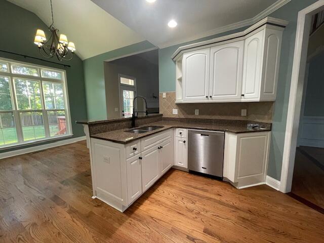 1212 Sumter Landing Ln, Evans, GA 30809 - kitchen with stainless steel dishwasher, a peninsula, a chandelier, light wood finished floors, and vaulted ceiling