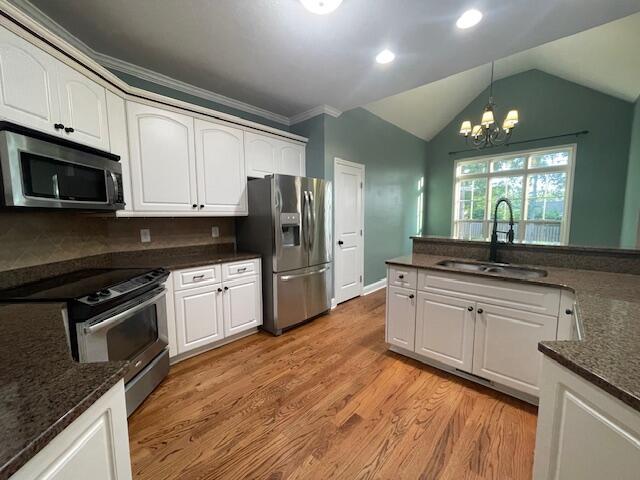 1212 Sumter Landing Ln, Evans, GA 30809 - kitchen featuring appliances with stainless steel finishes, white cabinets, hanging light fixtures, light wood-style flooring, and a chandelier