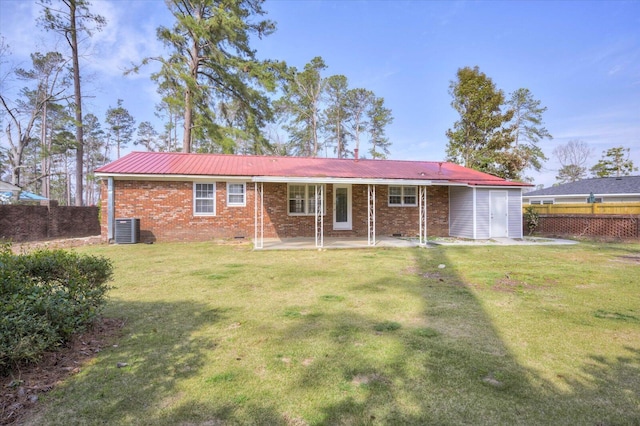 rear view of property with cooling unit, brick siding, a lawn, and fence