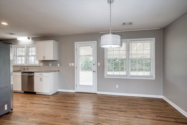 kitchen featuring appliances with stainless steel finishes, white cabinetry, baseboards, and wood finished floors