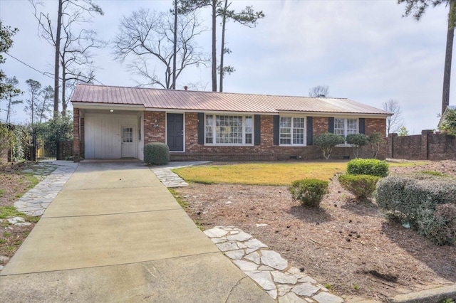 single story home featuring concrete driveway, a carport, a front yard, and metal roof