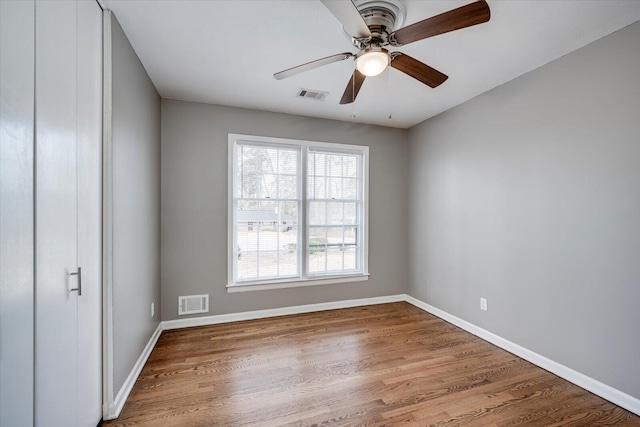 unfurnished bedroom featuring visible vents, baseboards, wood finished floors, and a ceiling fan