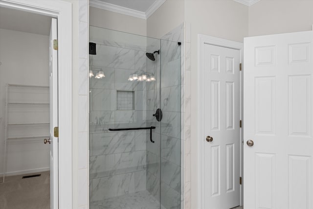 bathroom featuring a shower with door and ornamental molding