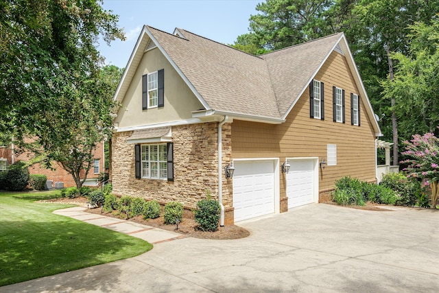 view of side of home with a garage and a lawn