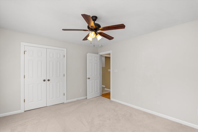 unfurnished bedroom with ceiling fan, a closet, and light colored carpet