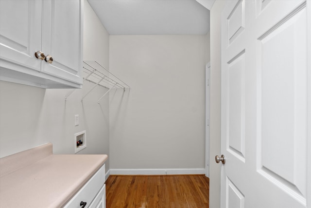 washroom featuring hookup for a washing machine, cabinets, and light hardwood / wood-style flooring