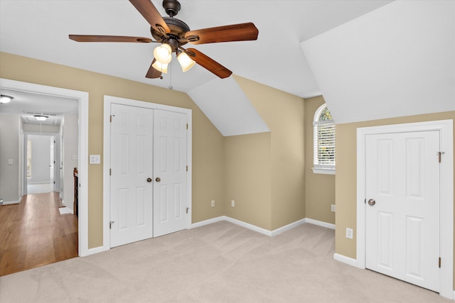 additional living space with ceiling fan, lofted ceiling, and light carpet