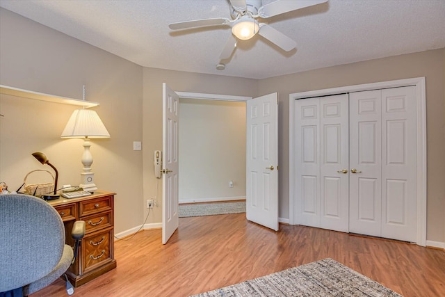 office area featuring ceiling fan, light hardwood / wood-style floors, and a textured ceiling