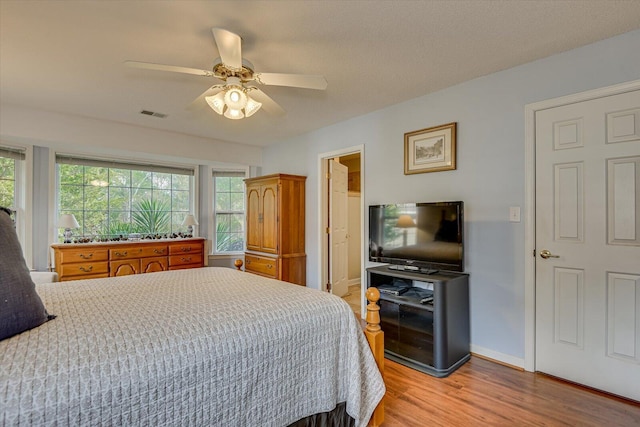 bedroom featuring ceiling fan, a textured ceiling, and light wood-type flooring