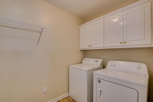 laundry room with washer and clothes dryer, light tile patterned flooring, cabinets, and a textured ceiling